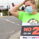 Rideshare driver Erica Mighetto holds up a a sign supporting a no vote on Proposition 22 in Oakland, California on October 9, 2020.